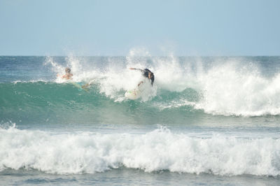 Man surfing in sea against sky