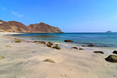 Scenic view of beach against blue sky