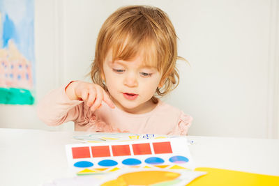 Portrait of cute girl playing with toy blocks on table