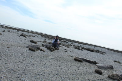 Rear view of man sitting on beach