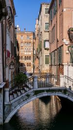 Bridge over canal amidst buildings in city