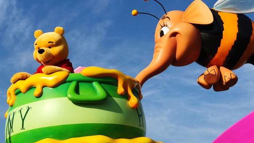 Low angle view of toys in amusement park against sky