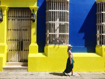 Woman walking against building in city