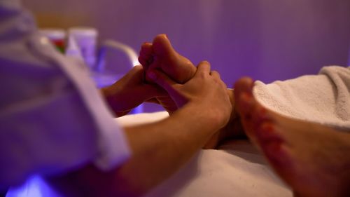Midsection of woman relaxing on bed