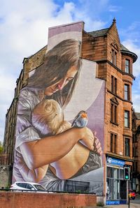 Midsection of woman against built structure against sky