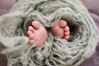 Low section of baby covered in wool