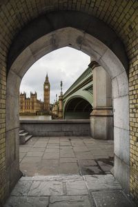 Big ben seen through arch bridge in city