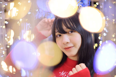 Portrait of young woman holding christmas tree