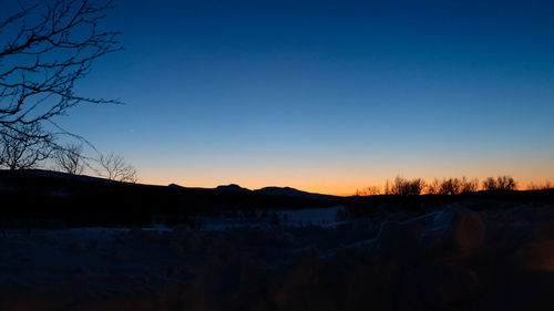 Scenic view of silhouette landscape against clear sky during sunset
