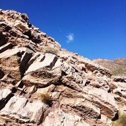 Low angle view of mountain against blue sky