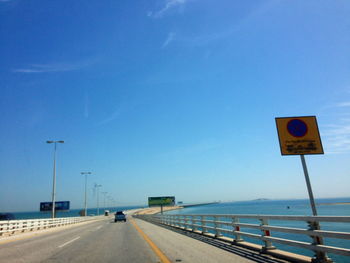 Road sign against blue sky