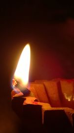 Burning candle in dark room