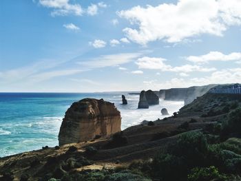 Cliff by sea against sky