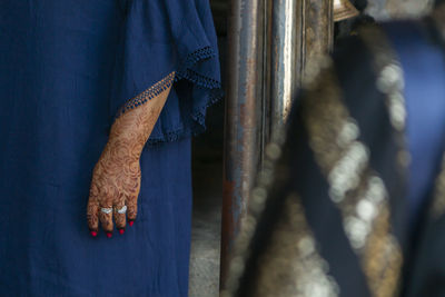 Midsection of woman with henna tattoo standing on floor