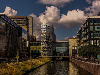 Buildings in city against cloudy sky