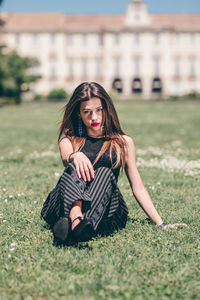 Portrait of young woman sitting on field