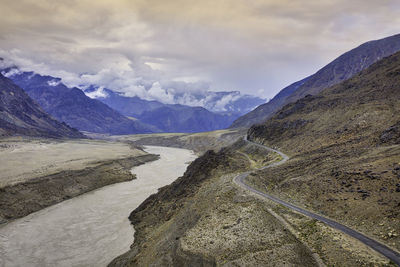 Scenic view of road by mountains against sky