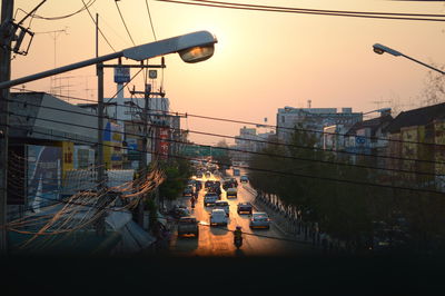 Bridge over cityscape against sky during sunset