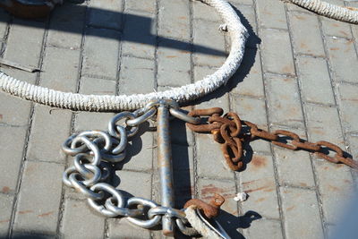 High angle view of rope tied on metal chain