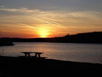 Scenic view of silhouette beach against sky during sunset