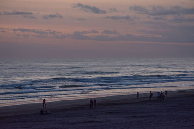 Scenic view of beach against sky at sunset