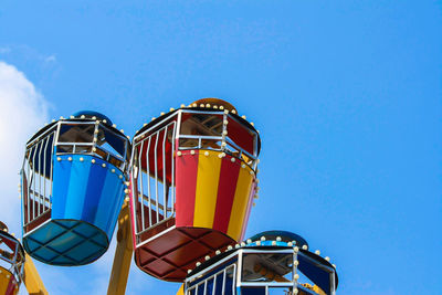 Low angle view of ferris wheel against blue sky