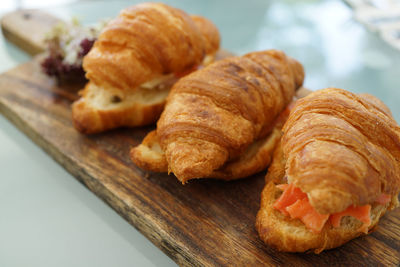 High angle close-up of salmon croissant served on cutting board on table