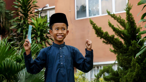 Portrait of smiling boy standing against plants