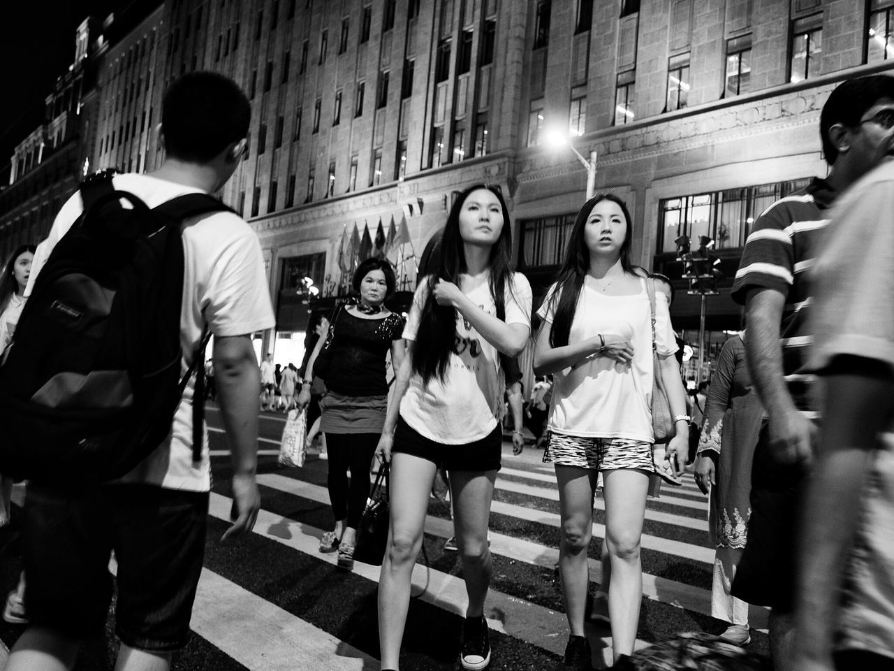 men, building exterior, architecture, built structure, standing, medium group of people, togetherness, city, street, person, illuminated, full length, lifestyles, casual clothing, in a row, outdoors, city life, busy, rush hour