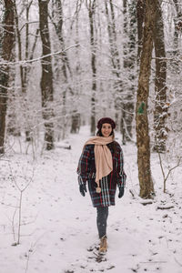 Rear view of woman walking on snow covered field