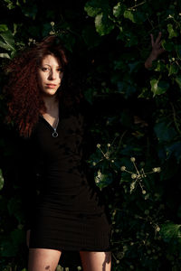 Portrait of woman standing against plants