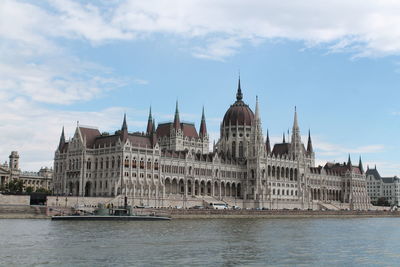 Buildings in city against cloudy sky