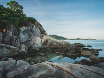 Rock formation on beach against sky