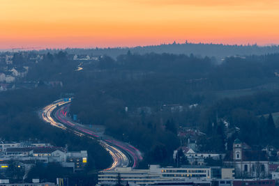 High angle view of illuminated city against sky at sunset