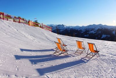 Scenic view of deck chairs against mountain landscape 