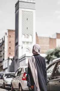Rear view of woman walking on street in paris city grand mosque