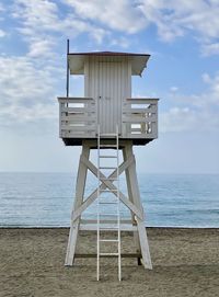 Lifeguard tower on a deserted beach on a clear day with white clouds 