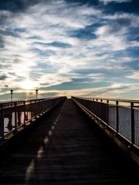 View of pier against cloudy sky at sunset