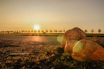 Hay bales on field against sky during sunset