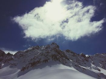 Low angle view of snowcapped mountains against sky