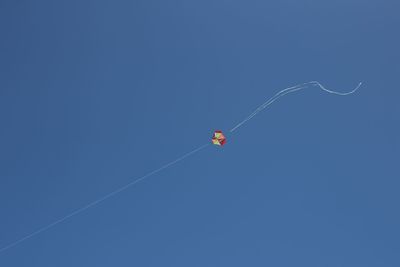 Low angle view of kite against clear blue sky