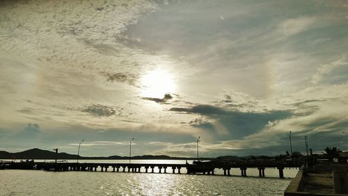 Pier over sea against sky during sunset