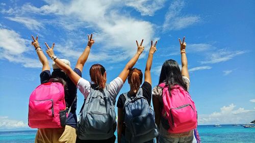 Rear view of women against blue sky