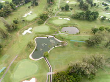 Aerial view of a golf course with a bunker and pond