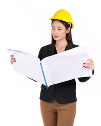 Young woman wearing hat standing against white background