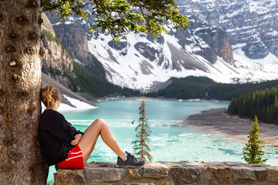 Side view of woman looking away at lake and mountain range