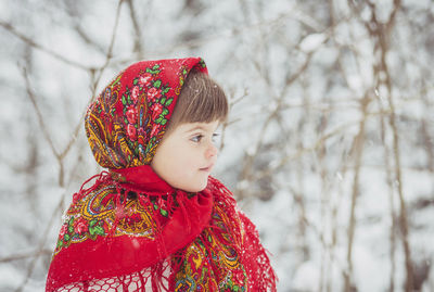 Portrait of young woman standing against trees