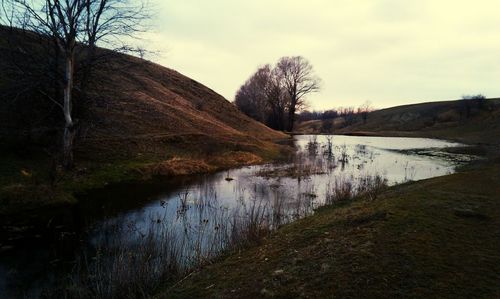 Scenic view of river against cloudy sky