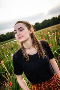 Portrait of a beautiful young woman standing on field