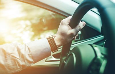 Cropped hand of man driving car